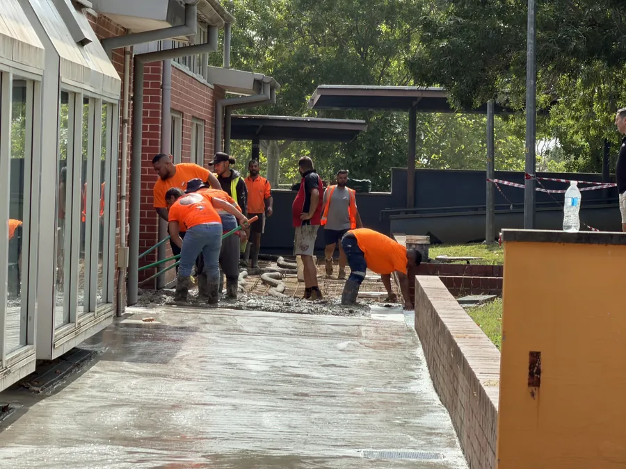 Baywa crew working behind barrier tape beside an occupied building
