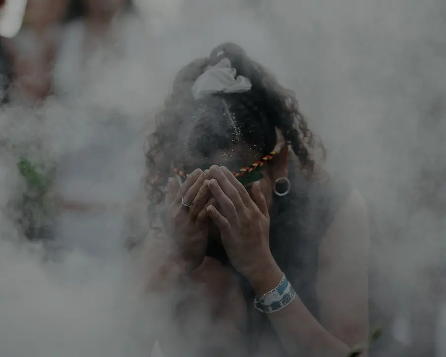 A person cleansing in the smoke of a smoking ceremony